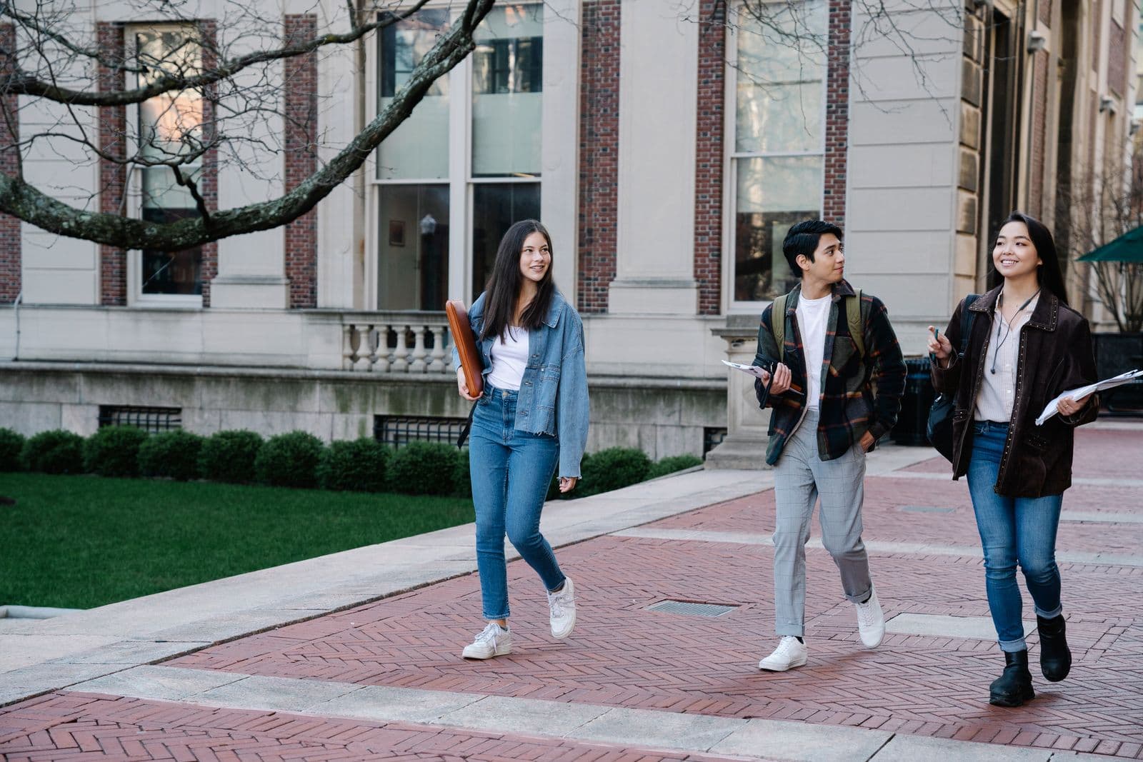 Students crossing a university campus in the afternoon sun